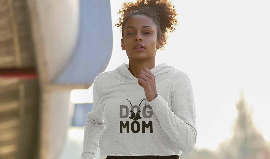 Beautiful woman jogging wearing the Heather Gray Dog Mom Cropped Hoodie from online outerwear and activewear clothing store for pet parents, they made me wear it.