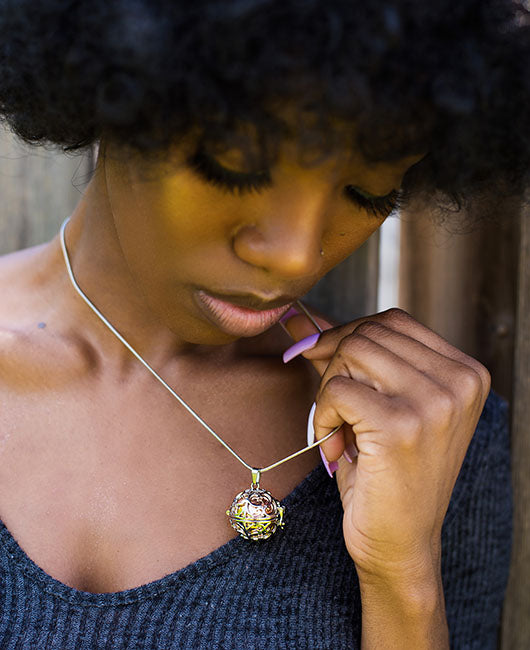 Beautiful black woman admiring Rose Gold Steampunk Memorial Urn Necklace from online keepsake jewelry shop they made me wear it.