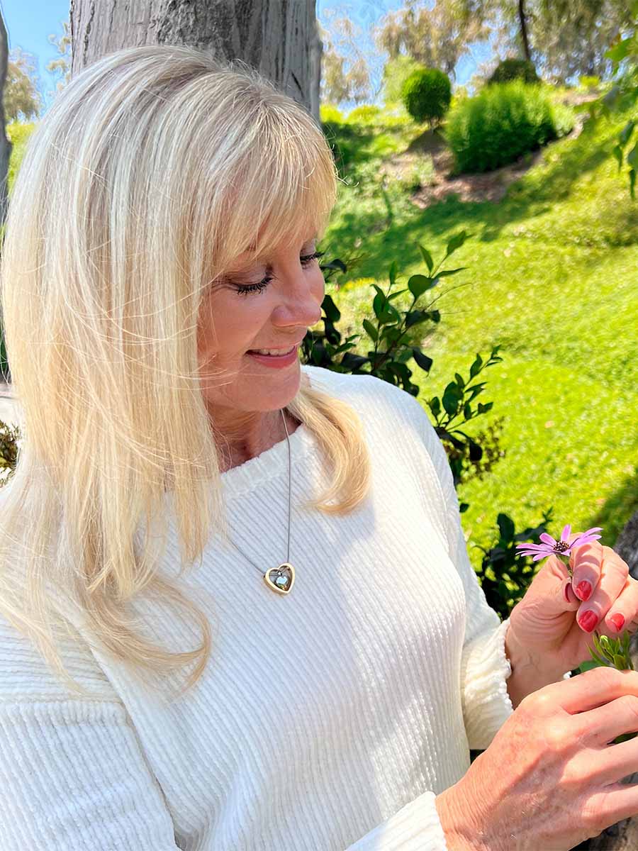Beautiful woman in her garden wearing Two Hearts Forever Urn Necklace from online keepsake jewelry shop they made me wear it.