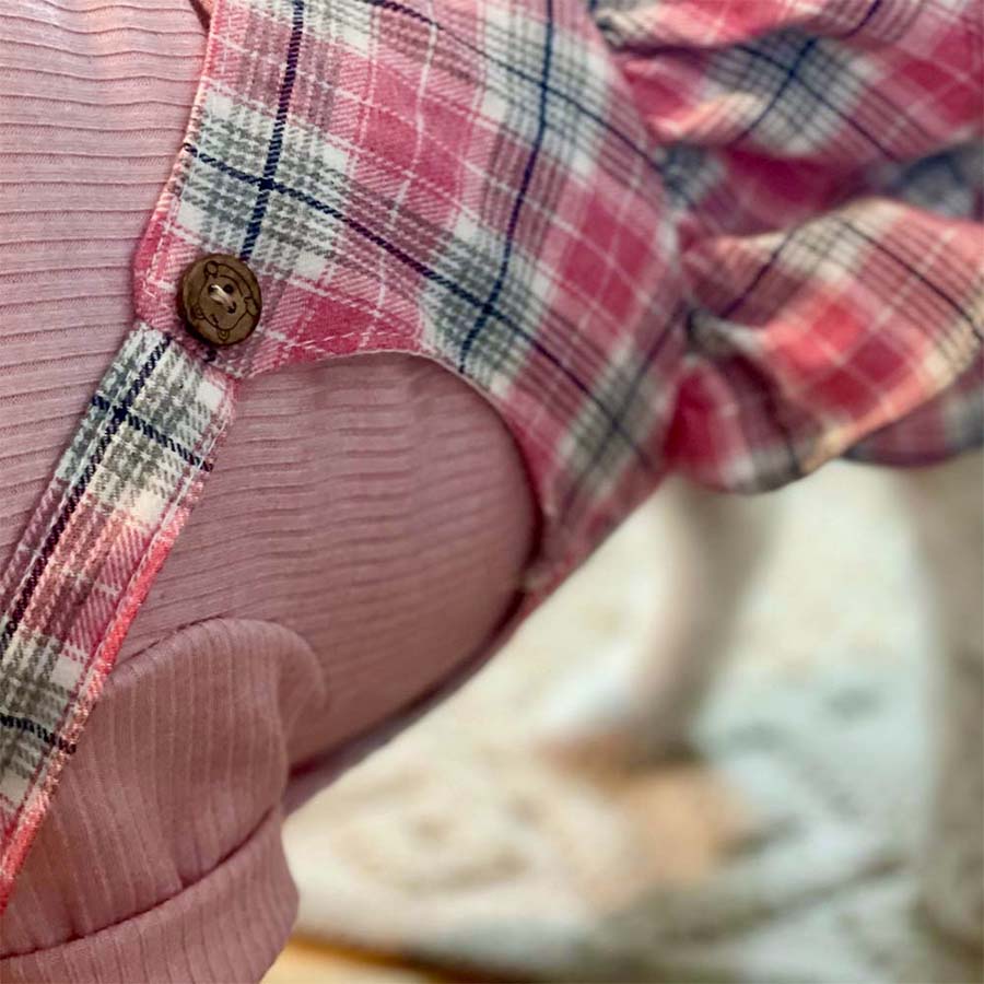 Close up of wooden button on the strap of the Pretty in Pink Dog Romper and Turtleneck from online posh puppy boutique they made me wear it.