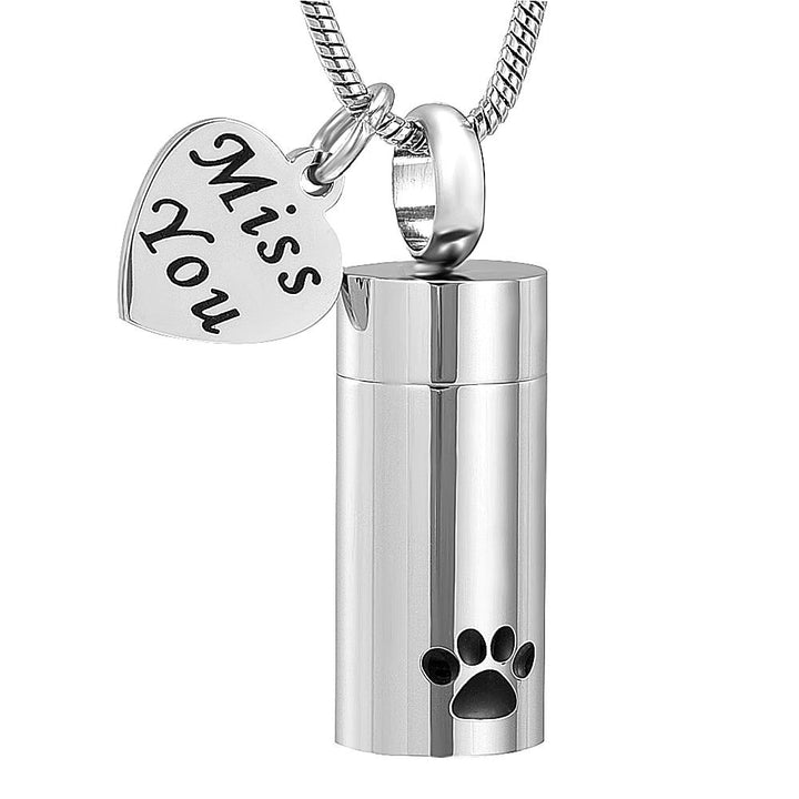 Beautiful Cremation Necklace featuring an urn with paw prints and a lovely heart-shaped tag engraved with the words "Miss You". The perfect bereavement gift for family and friends who want to wear an urn necklace to hold a small amount of pet ashes to remember their pet who crossed over the rainbow bridge. Available from online boutique they made me wear it.